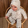 Jules participe au concours pour gagner de l'argent avec cette photo : baby, child, cozy, cute, footwear, happy, hooded_clothing, indoor, infant, knitwear, person, portrait, sitting, small_chair, smile, socks, warm_clothing, wicker_chair, wood_floor, wood_paneling