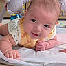 baby, infant, smiling, tummy_time, plush_toy, koala_toy, cute, child, soft_toys, indoor, carpet, bib, clothing, portrait, close_up, happy, face, hand, skin, baby_playmat