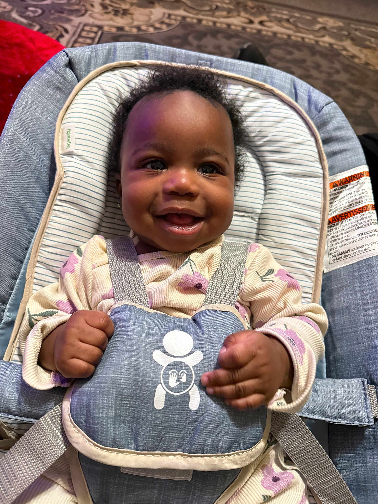Ahzani is registered to the contest to win money with this photo: baby, smiling, infant, child, baby_seat, straps, clothing, floral_pattern, happy, face, hands, indoors, carpet, cute, person, toddler, baby_girl, seat, padded, safety