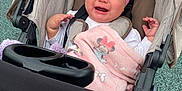 Avia is registered to the contest to win money with this photo: accessory, baby, blanket, child, clothing, comfort, crying, expression, fabric, headband, infant, outdoor, person, pink, playground, seat, sitting, stroller, toy, upset