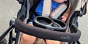 Avia is registered to the contest to win money with this photo: baby, baby_girl, baby_toy, blue_socks, child, child_in_stroller, clothing, curious, cute, evenflo, footwear, headband, infant, outdoor, pavement, person, playing, seatbelt, stroller, toy