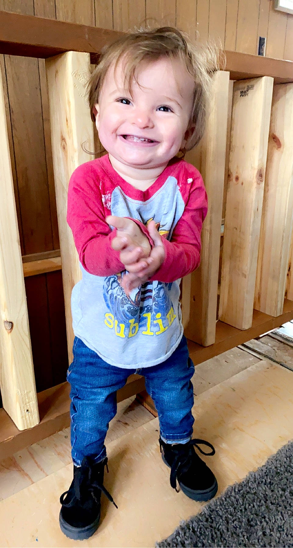 Phoebe is registered to the contest to win money with this photo: baby, baby_toddler_clothing, cheek, eye, face, floor, flooring, gesture, hair, happy, head, joy, nose, person, product, skin, sleeve, smile, standing, thumb
