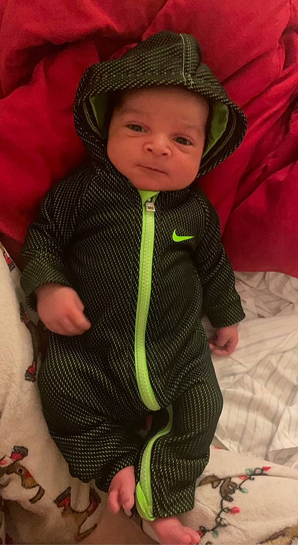 Amari is registered to the contest to win money with this photo: baby, baby_products, baby_toddler_clothing, cheek, child, comfort, eye, face, facial_expression, fashion_accessory, head, headwear, human_body, jacket, linens, pattern, person, skin, sleeve, toddler