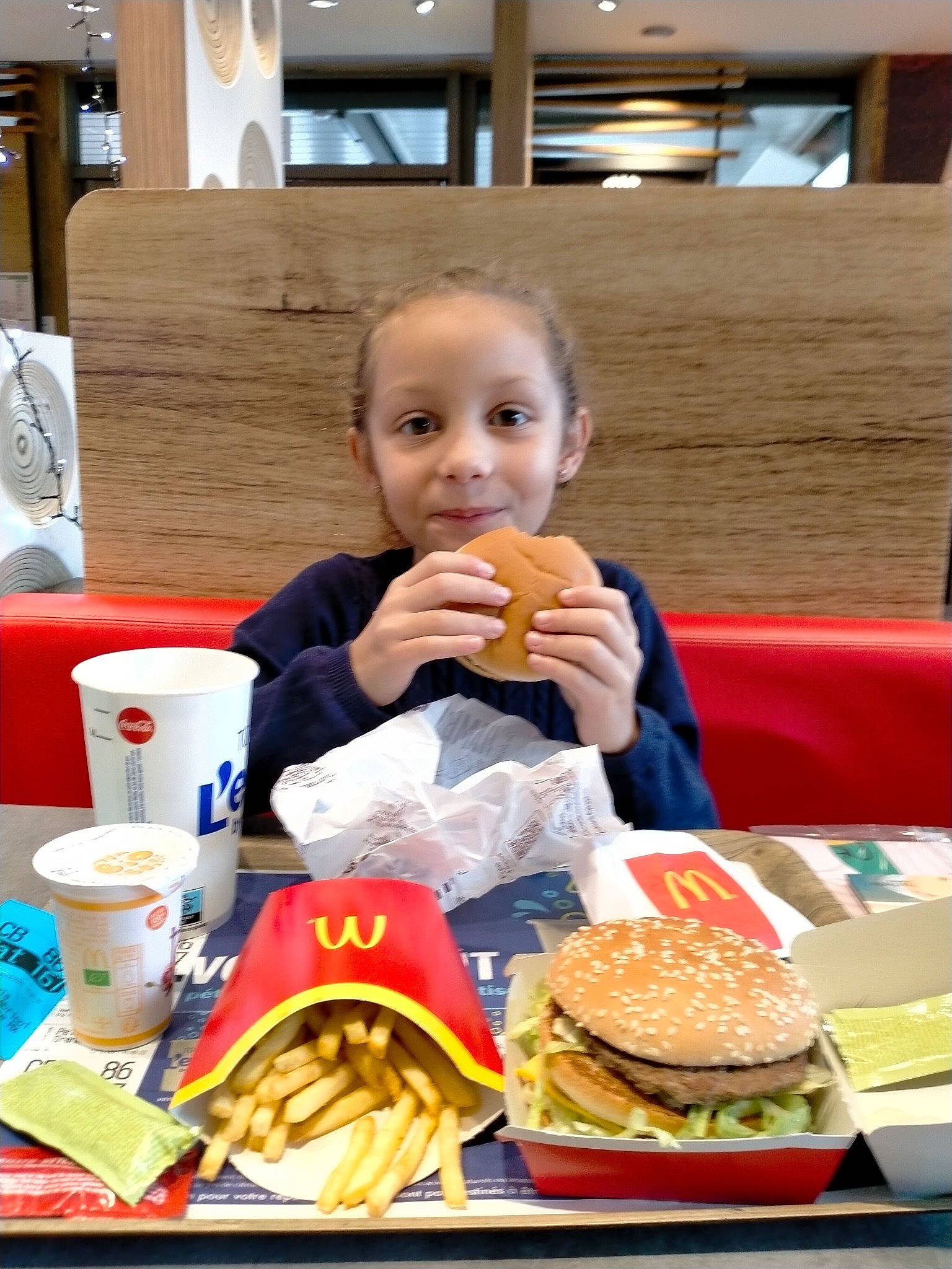 Louane participe au concours pour gagner de l'argent avec cette photo : bun, chair, cuisine, dish, fast_food, food, food_craving, fried_food, hamburger, ingredient, joy, junk_food, person, plate, sandwich, sharing, smile, staple_food, table, tableware