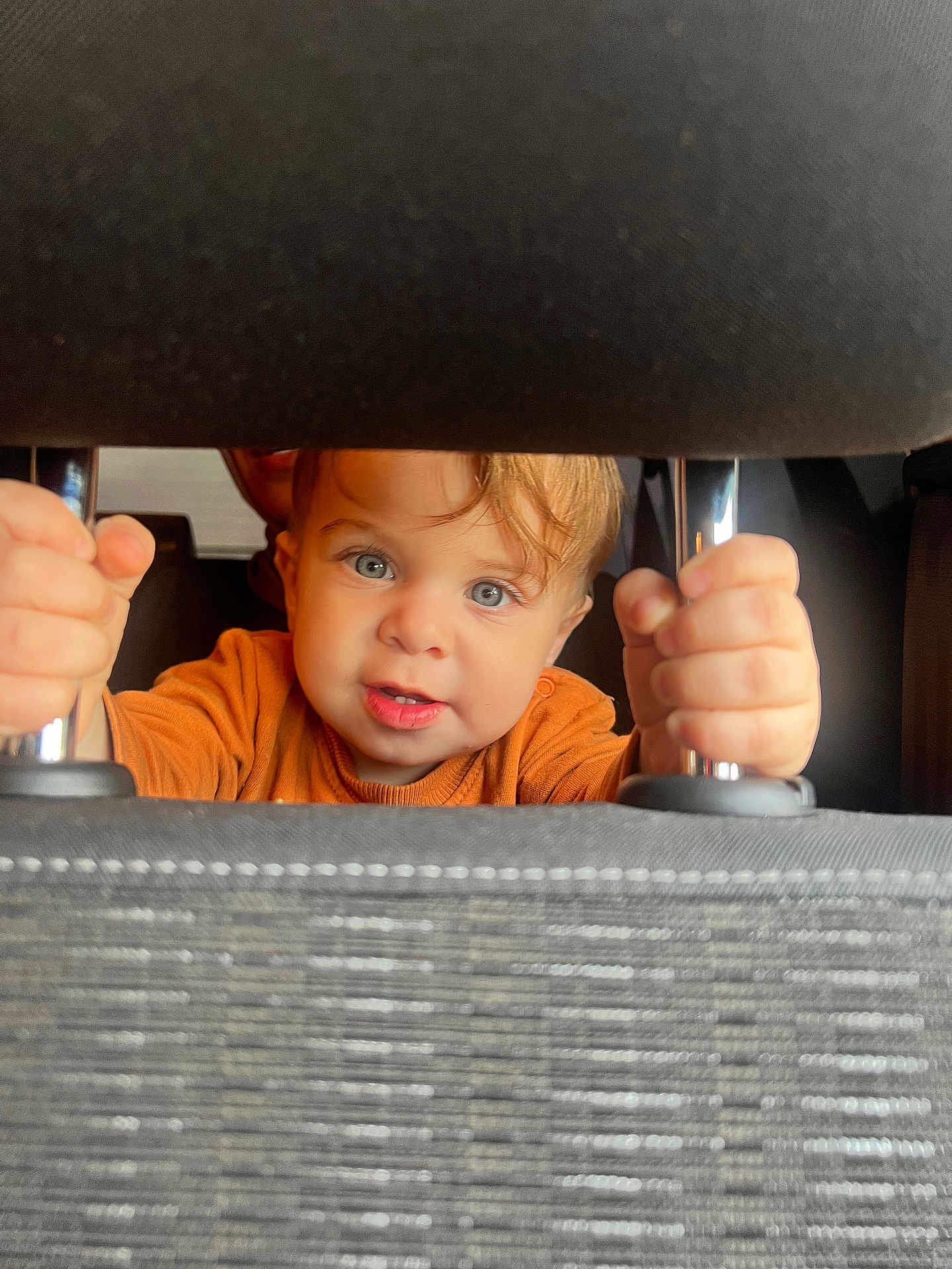 Mehmetcan a rejoint le concours — aidez-le/la à gagner de superbes lots ! toddler, child, car_seat, headrest, hands, blue_eyes, curly_hair, orange_shirt, car_interior, metal_rods, peeking, closeup, portrait, baby, cute, grip, seat, seatbelt, vehicle, inside