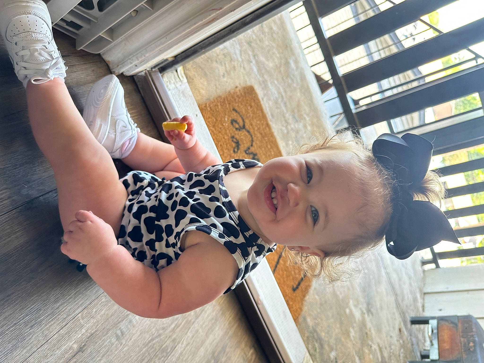 Emery is registered to the contest to win money with this photo: child, elbow, eyewear, fun, gesture, happy, human_leg, joint, knee, laugh, leisure, pattern, person, shoulder, sitting, smile, t_shirt, thigh, toddler, tree