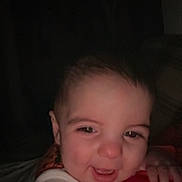 Waylon is registered to the contest to win money with this photo: baby, smiling, face, hand, child, infant, closeup, portrait, happiness, dark_background, candid, cute, person, skin, eyebrows, eyes, mouth, clothing, sleeve, holding