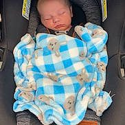 River is registered to the contest to win money with this photo: baby, blanket, car_seat, child, clothing, comfort, cozy, cute, fabric, face, indoor, infant, newborn, peaceful, portrait, resting, seatbelt, sleeping, soft, warning_label