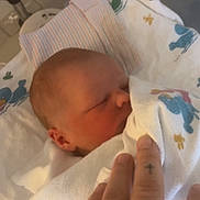 Christopher is registered to the contest to win money with this photo: newborn, baby, hospital, blanket, bassinet, hand, sleeping, infant, person, tender, resting, cute, small, wrapped, face, skin, bed, soft, closeup, indoor