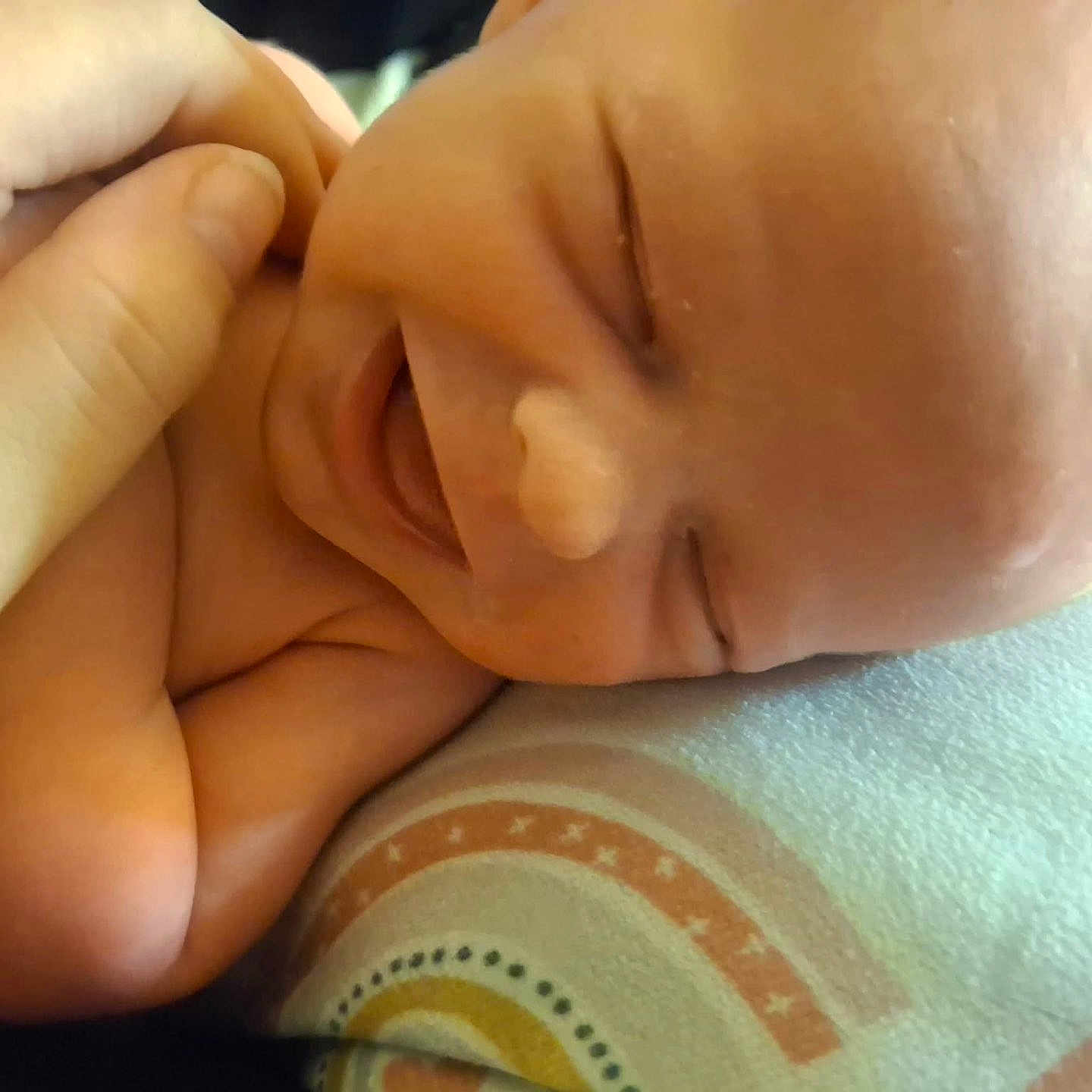 Christopher is registered to the contest to win money with this photo: baby, newborn, smiling, face, hand, skin, blanket, infant, closeup, cute, joy, lying_down, human, child, toddler, sleepy, peaceful, soft, portrait, happy