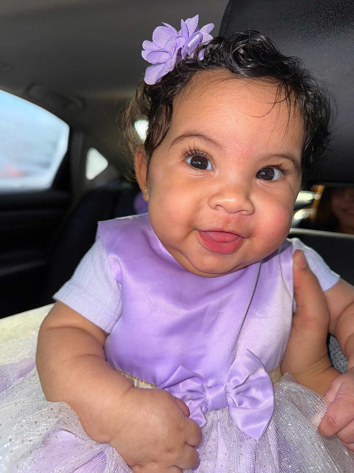 Geanna is registered to the contest to win money with this photo: baby, child, smiling, dress, lavender, flower, headband, car, seat, hand, cute, portrait, cute_face, infant, happy, tongue_out, chubby_cheeks, clothing, person, indoor