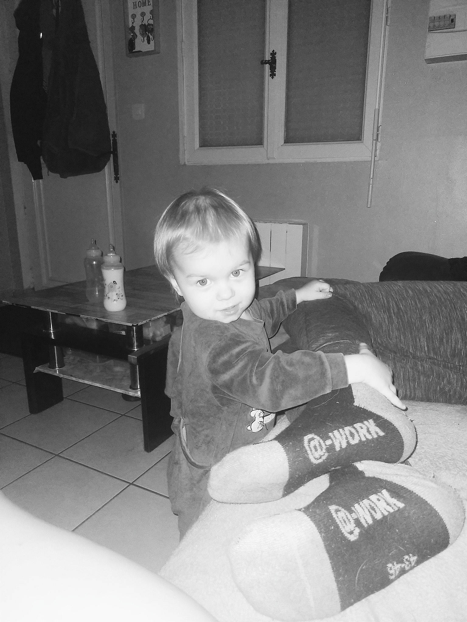 Léo a rejoint le concours — aidez-le/la à gagner de superbes lots ! baby, black, black_and_white, child, comfort, door, flooring, house, knee, lamp, living_room, monochrome, monochrome_photography, person, picture_frame, room, sitting, standing, style, toddler