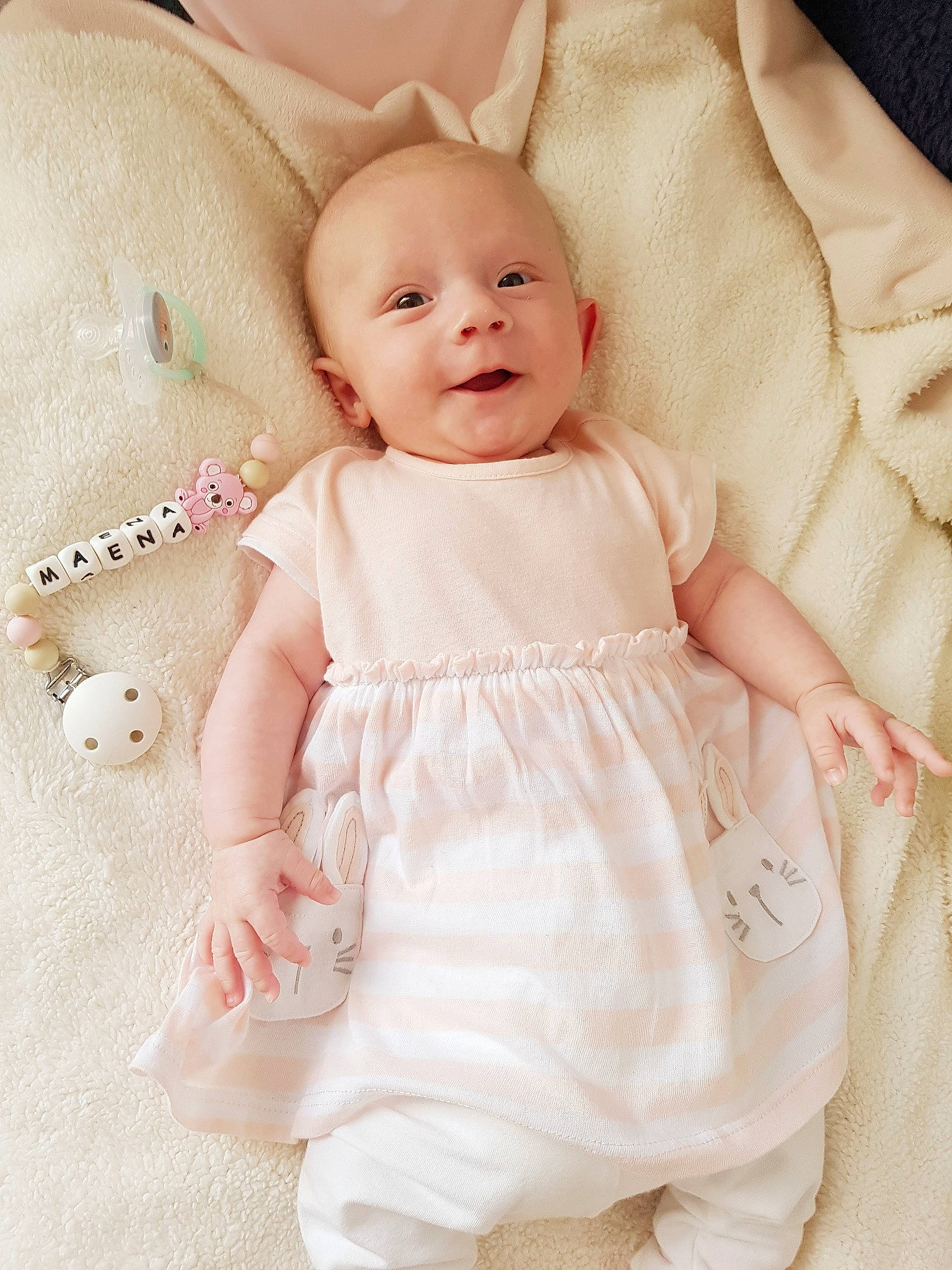 Maena a rejoint le concours — aidez-le/la à gagner de superbes lots ! baby, baby_toddler_clothing, beige, cheek, child, collar, comfort, day_dress, dress, face, happy, one_piece_garment, pattern, person, pink, skin, sleeve, smile, textile, toddler