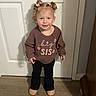 child, toddler, girl, portrait, smiling, standing, indoors, door, doorknob, sweater, big_sis, pink_bows, pigtails, black_pants, boots, wood_floor, home, full_body, happy, photograph
