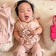Caliah Fleur joined the competition — help win amazing prizes! baby, infant, pink_outfit, rose, cushion, plush_toy, handbag, flowers, smiling, happy, lying_down, indoors, cute, child, soft_texture, decor, small_bag, toy, person, portrait