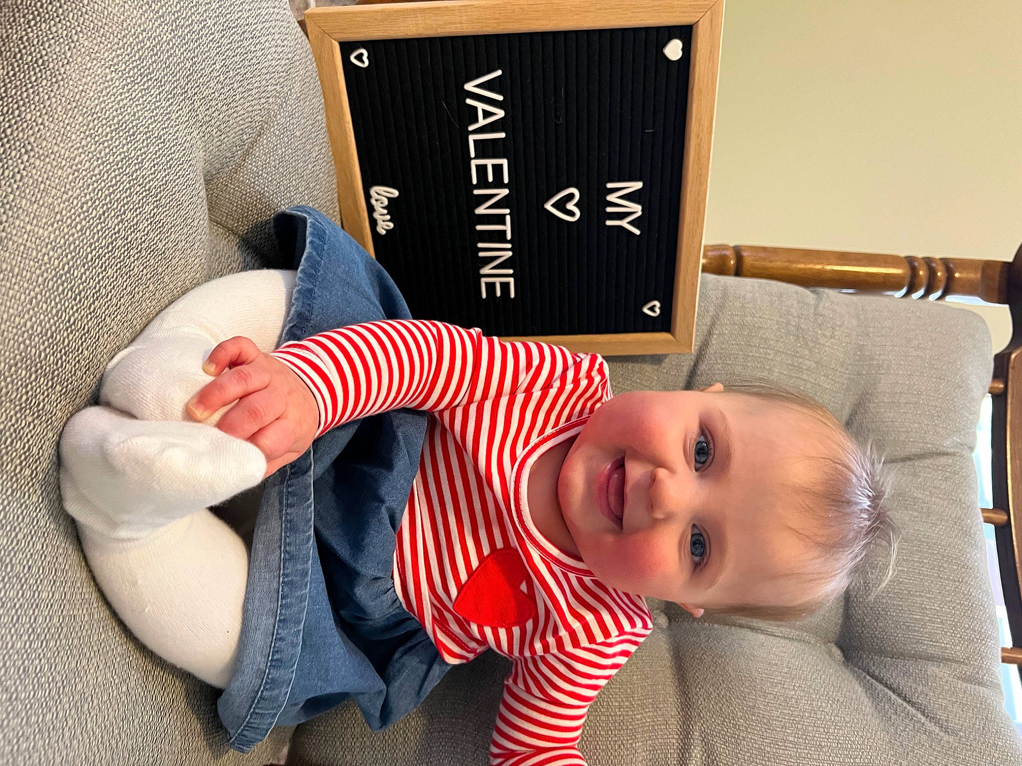 Annmarie is registered to the contest to win money with this photo: baby, baby_toddler_clothing, chin, comfort, dress, finger, flooring, foot, hairstyle, happy, hat, human_leg, joy, knee, person, sitting, sleeve, smile, thumb, toddler