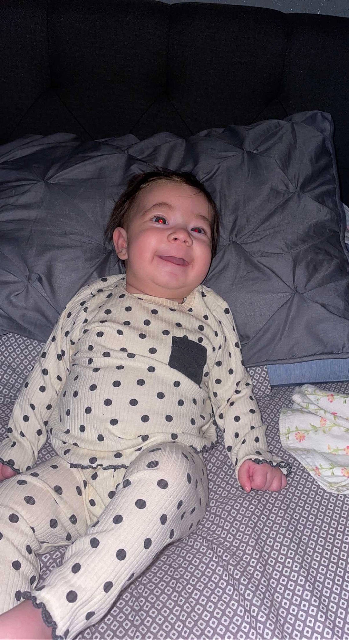 Kinsley is registered to the contest to win money with this photo: baby, baby_products, baby_toddler_clothing, bed_sheet, bedding, child, comfort, eye, face, flooring, fun, joy, linens, pattern, person, room, sitting, skin, sleeve, smile