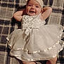 Willow joined the competition — help win amazing prizes! baby, infant, white_dress, headband, smiling, happy, plaid_blanket, relaxed, cute, chubby_arms, lying_down, indoors, child, adorable, portrait, fabric, soft_lighting, toddler, person, sleepwear