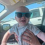 Weston joined the competition — help win amazing prizes! baby, child, sunglasses, car_interior, smiling, hand, tshirt, seat, window, daylight, parking_lot, person, holding, happy, cute, casual_clothing, accessory, human, sunlight, fun