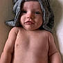 baby, infant, towel, headwear, bare_chest, lying_down, skin, face, eyes, mouth, arm, shoulder, soft_surface, indoor, cute, child, person, newborn, portrait, closeup