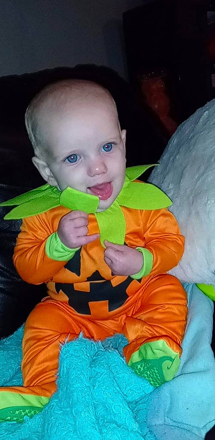 Blake is registered to the contest to win money with this photo: baby, baby_products, baby_toddler_clothing, baby_toys, cheek, child, costume, event, fictional_character, fun, happy, head, iris, orange, person, personal_protective_equipment, play, sitting, stuffed_toy, textile