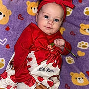 Holly joined the competition — help win amazing prizes! baby, infant, child, red_clothing, headband, flower, blanket, bear_pattern, heart_pattern, cute, portrait, laying_down, indoors, soft_texture, adorable, person, toddler, closeup, smiling, baby_dress