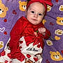 baby, infant, child, red_clothing, headband, flower, blanket, bear_pattern, heart_pattern, cute, portrait, laying_down, indoors, soft_texture, adorable, person, toddler, closeup, smiling, baby_dress