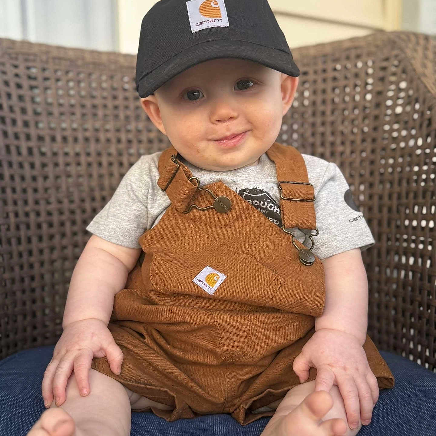 River is registered to the contest to win money with this photo: baby, baseballcap, bodypart, cap, clothing, face, happy, hat, head, heel, indoors, jeans, pants, person, photography, portrait, sitting, sleeve, smile, sunhat