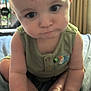 Mason is registered to the contest to win money with this photo: baby, child, infant, face, eyes, hands, feet, green_clothing, toucan_patch, indoor, curtains, bed, blanket, soft_light, pout, curious, sitting, skin, person, caucasian