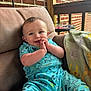 baby, child, smiling, blue_outfit, shark_pattern, cushioned_chair, blanket, brick_wall, porch, wooden_railing, happy, face, hands, sitting, indoor, cute, infant, clothing, comfort, portrait