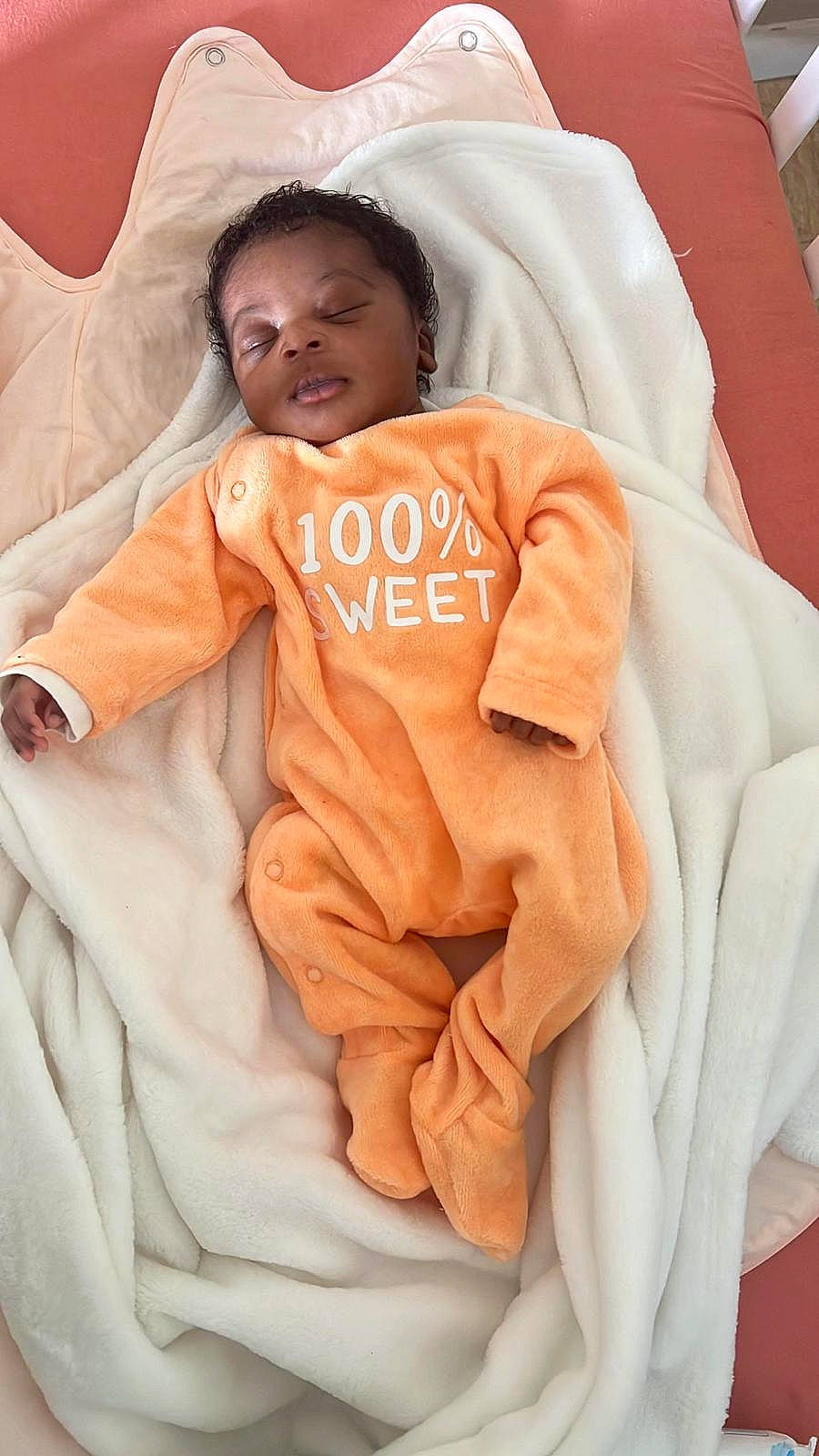Maelys participe au concours pour gagner de l'argent avec cette photo : baby, baby_sleeping, baby_toddler_clothing, child, comfort, event, face, gesture, happy, head, linens, orange, peach, person, pink, skin, sleeve, smile, toddler, watch