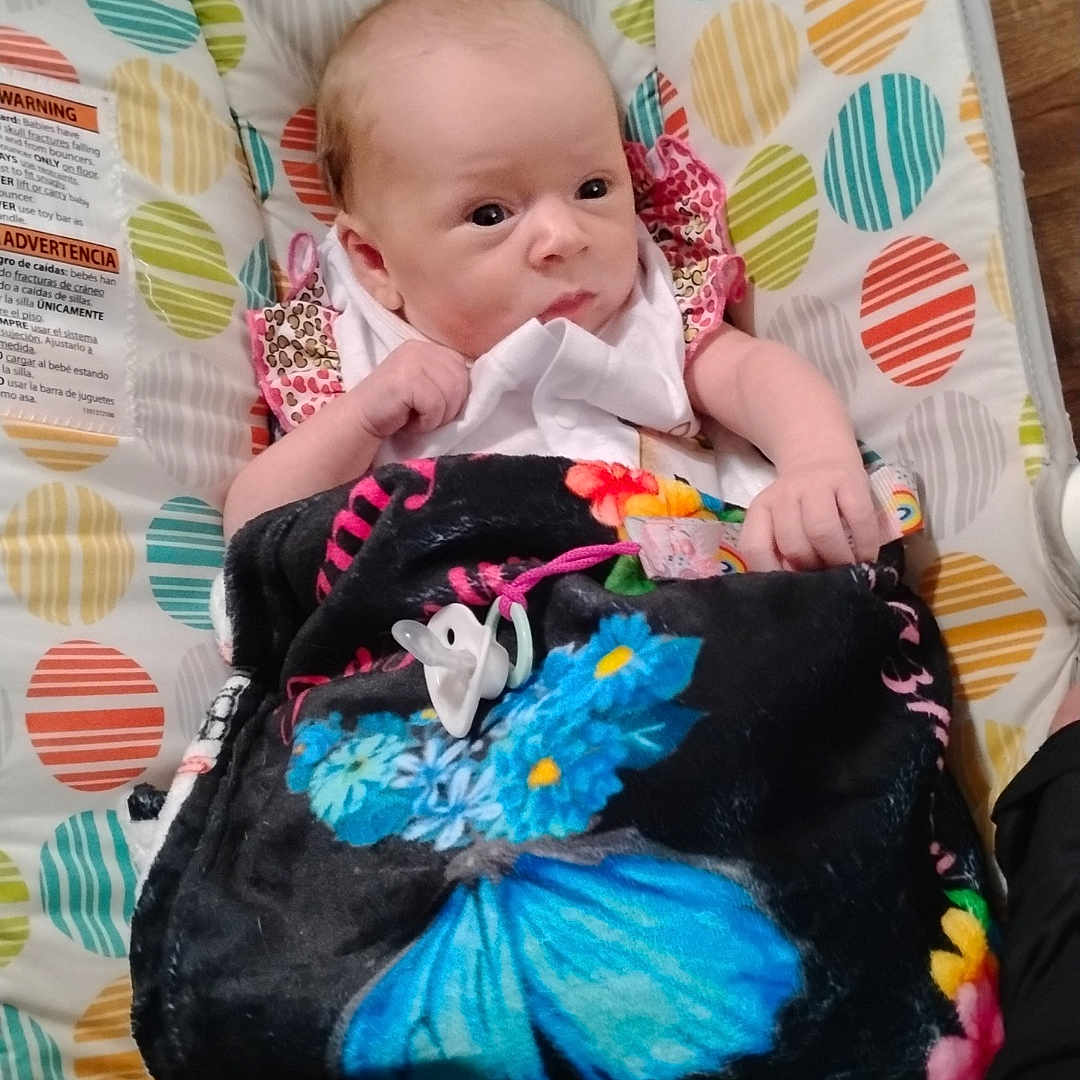 Jazmyn is registered to the contest to win money with this photo: baby, bed, blanket, clothing, couch, crib, cushion, dress, face, furniture, head, homedecor, infantbed, newborn, person, photography, pillow, portrait, quilt, sleeping