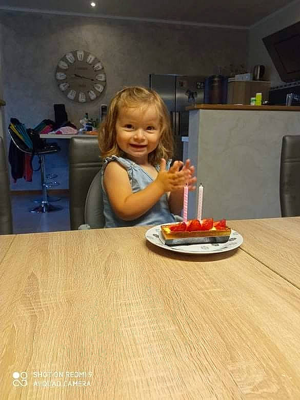 Clémence participe au concours pour gagner de l'argent avec cette photo : cake, cuisine, dartboard, dessert, dish, flooring, food, hardwood, ingredient, joy, laminate_flooring, person, plate, recipe, smile, sweetness, table, tableware, toddler, varnish