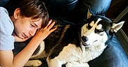 Zayley is registered to the contest to win money with this photo: boy, dog, husky, couch, leather, indoor, resting, pet, child, animal, black, white, fur, comfort, relaxation, home, companionship, friendship, portrait, casual