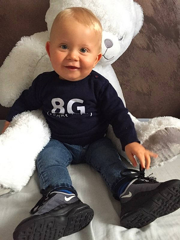 Tiago a rejoint le concours — aidez-le/la à gagner de superbes lots ! baby, baby_toddler_clothing, brown, cheek, ear, flash_photography, happy, mouth, nose, person, portrait_photography, sitting, sleeve, smile, sock, toddler