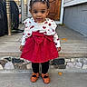child, toddler, girl, portrait, outdoor, front_steps, house, door, dress, red_dress, heart_pattern, bow, hair_bows, curly_hair, smiling, standing, shoes, leggings, sidewalk, daylight