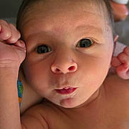 Gunner is registered to the contest to win money with this photo: baby, infant, closeup, face, expression, surprised, skin, blanket, colorful, pattern, arm, hand, indoors, bottle, newborn, portrait, cute, child, person, young