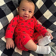 Karsyn joined the competition — help win amazing prizes! baby, infant, smile, red_clothing, spiderman_pattern, white_socks, blanket, checkered_pattern, cozy, happy, cute, child, lying_down, portrait, indoors, soft_texture, face, small_hand, footwear, warm
