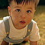 Austin is registered to the contest to win money with this photo: child, toddler, face, eyes, hair, outdoor, grass, crawling, clothing, white_shirt, overalls, dirt, messy_face, sunlight, portrait, cute, baby, nature, daylight, expression