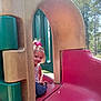 child, girl, playground, slide, outdoor, smiling, pink_bow, jeans, tank_top, daylight, trees, park, play_equipment, fun, cute, happy, nature, sunny, recreation, leisure
