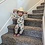 toddler, child, stairs, carpet, hat, cowboy_hat, pajamas, barefoot, indoor, smiling, young_child, person, home, wall, railing, footwear, sitting, cute, playful, casual