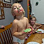 toddler, child, cookie, frosting, green_frosting, red_frosting, face_paint, kitchen, table, plate, holiday_lights, window_blinds, chair, diaper, messy, smiling, fun, indoor, family, siblings