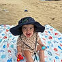 toddler, child, beach, sand, sunhat, toy, blanket, sea, ocean, umbrella, smiling, happy, play, summer, vacation, outdoor, person, cute, leopard_print, foot