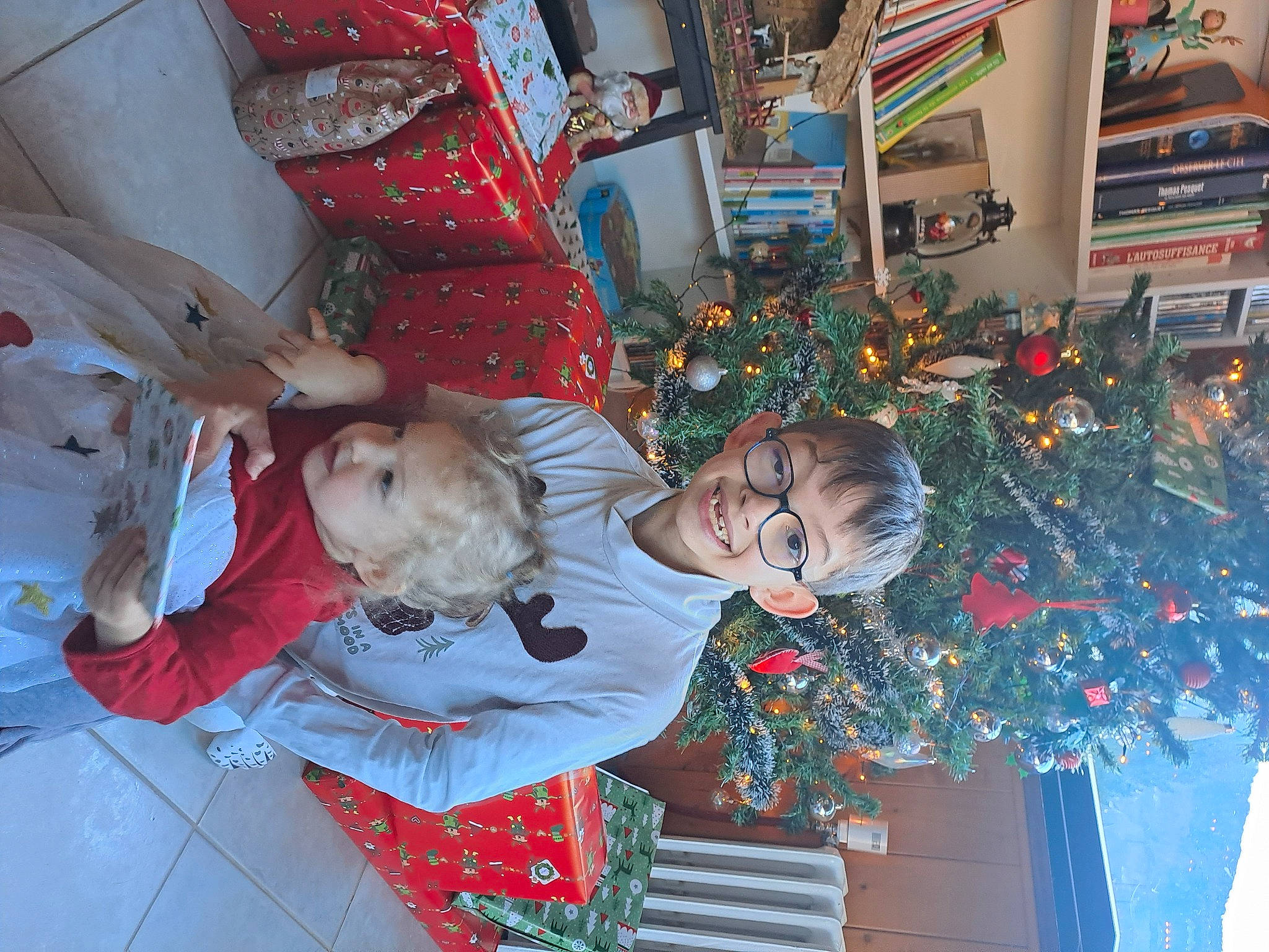 Nanou a rejoint le concours — aidez-le/la à gagner de superbes lots ! carmine, child, christmas, christmas_decoration, christmas_eve, christmas_ornament, christmas_tree, event, fun, happy, holiday, holiday_ornament, interior_design, joy, lap, ornament, person, plant, room, toddler