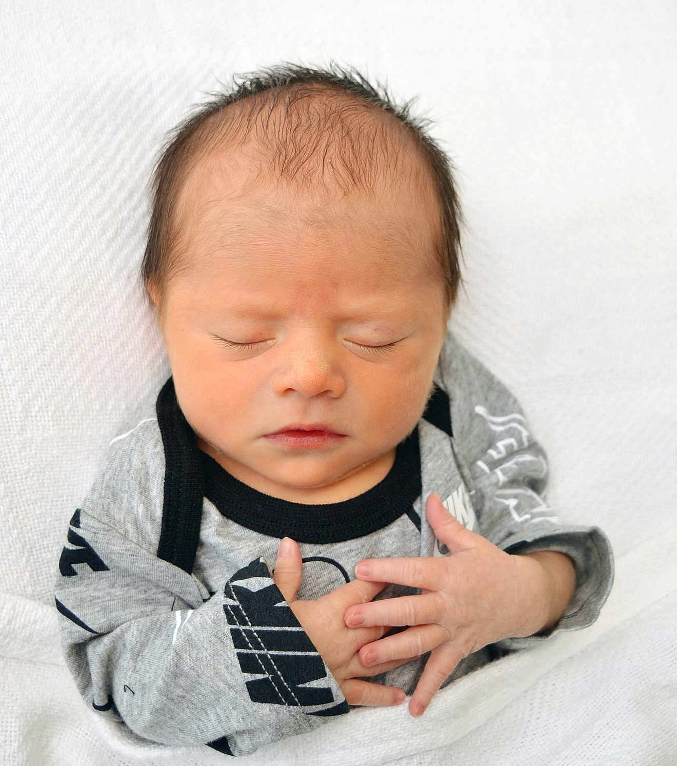 Elias joined the competition — help win amazing prizes! baby, newborn, infant, sleeping, closed_eyes, peaceful, face, head, hair, skin, hands, onesie, gray_onesie, swaddle, blanket, portrait, closeup, newborn_photo, tiny_fingers, soft_lighting