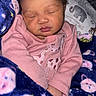 baby, sleeping, blanket, pink_clothing, crib, giraffe_print, animal_print, face, infant, cozy, child, cute, peaceful, bedding, soft, newborn, indoors, resting, wrapped, toddler
