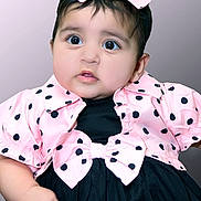 Amal Fatima joined the competition — help win amazing prizes! baby, child, polka_dot, pink, black, dress, headband, bow, portrait, cute, infant, face, hand, fashion, studio, background, closeup, expression, adorable, clothing