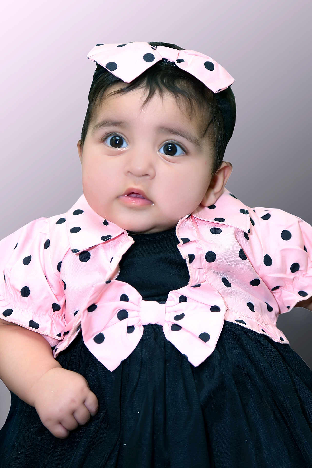 Amal Fatima joined the competition — help win amazing prizes! baby, child, polka_dot, pink, black, dress, headband, bow, portrait, cute, infant, face, hand, fashion, studio, background, closeup, expression, adorable, clothing