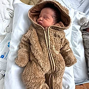 Kingston is registered to the contest to win money with this photo: baby, newborn, infant, sleeping, hooded_suit, fuzzy_suit, onesie, zipper, pillow, bed, hospital_bed, blanket, cozy, soft_texture, portrait, closed_eyes, peaceful_expression, lying_down, mittens, cute