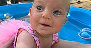 Hadley is registered to the contest to win money with this photo: baby, child, pool, water, swimsuit, pink, tutu, blue_eyes, outdoor, sunny, grass, hand, legs, skin, playful, summer, cute, infant, backyard, traffic_cone